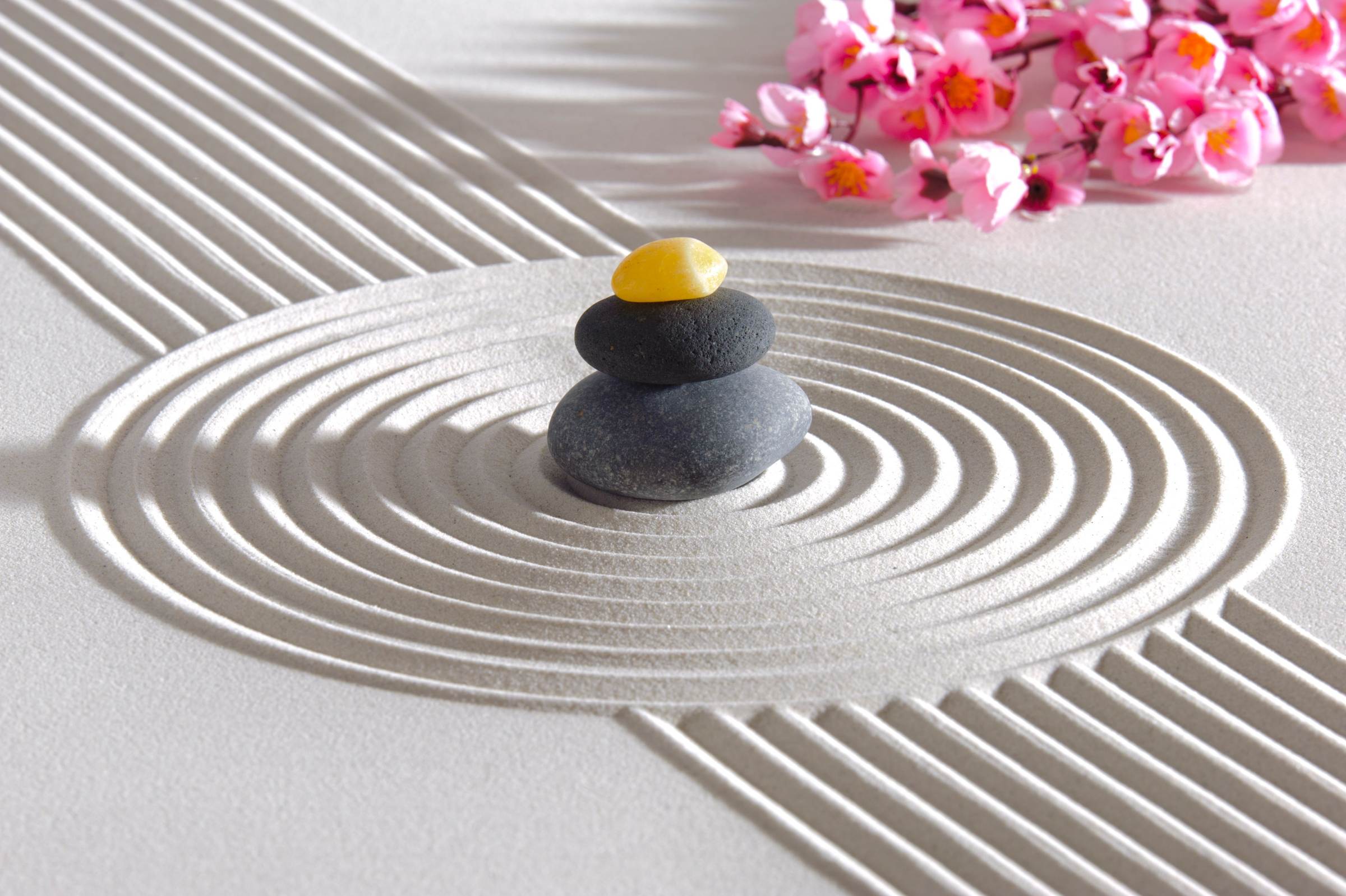 Serene zen-tuin met gestapelde stenen en zandpatronen, symbool voor innerlijke rust en balans tijdens energetische hypnose sessies met Maarten Wauters.