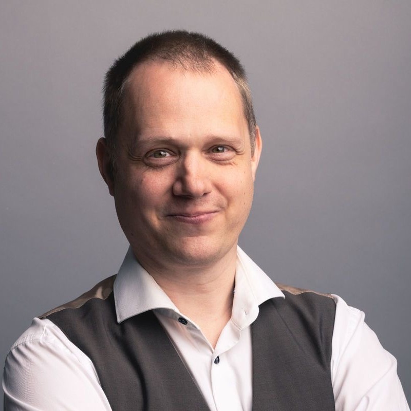 Professioneel portret van Maarten Wauters met een milde glimlach, die vertrouwen en deskundigheid toont.