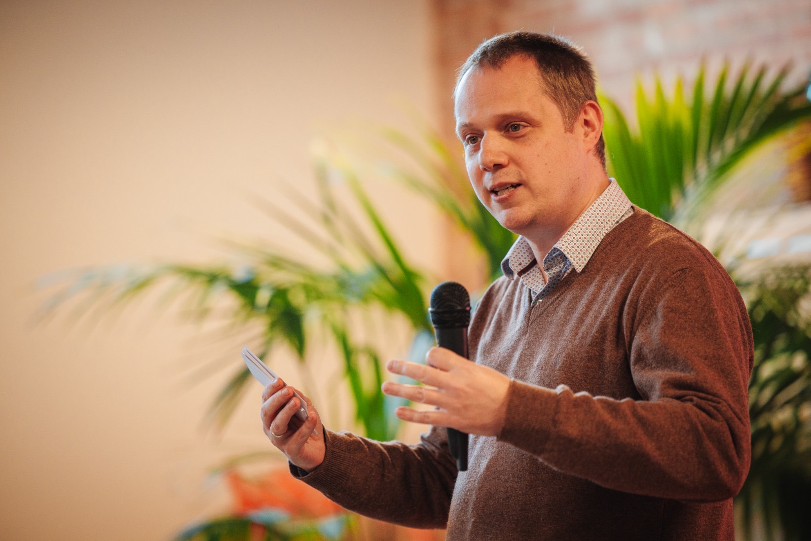 Foto van Maarten Wauters die spreekt met een microfoon tijdens een keynote over vertrouwen.
